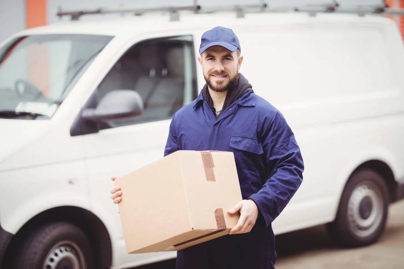 MBL same-day courier with a parcel beside the delivery van